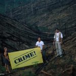 Paulo Adario and two other activists holding a banner "CRIME" in the Amazon forest, Para State, Brazil.